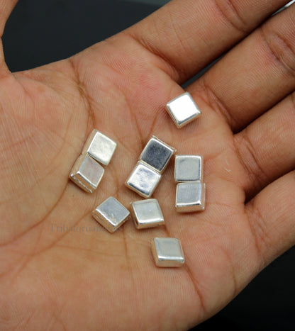 Tiny silver Barfi sweets and silver cake Prasadam for Diwali Puja, from Tribal Ornaments, traditional Indian silver worship article.