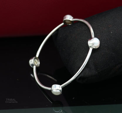 Sterling silver bangle with fresh water pearl and tribal-inspired design from Tribal Ornaments, stylish handmade jewelry.