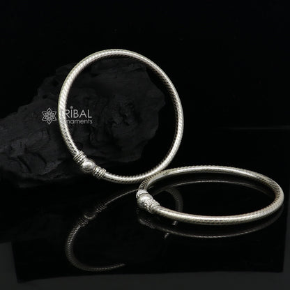 Sterling silver bangle bracelet with intricate tribal design by TRIBAL ORNAMENTS, showcasing customized jewelry craftsmanship.
