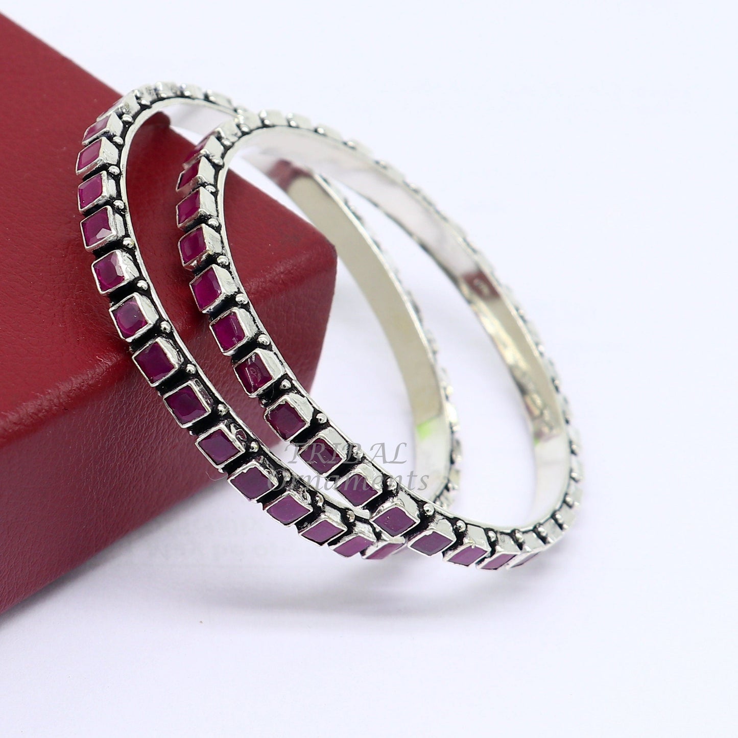 Sterling silver bangle bracelet with a red cut stone, featuring intricate tribal design, suitable for girls and women.