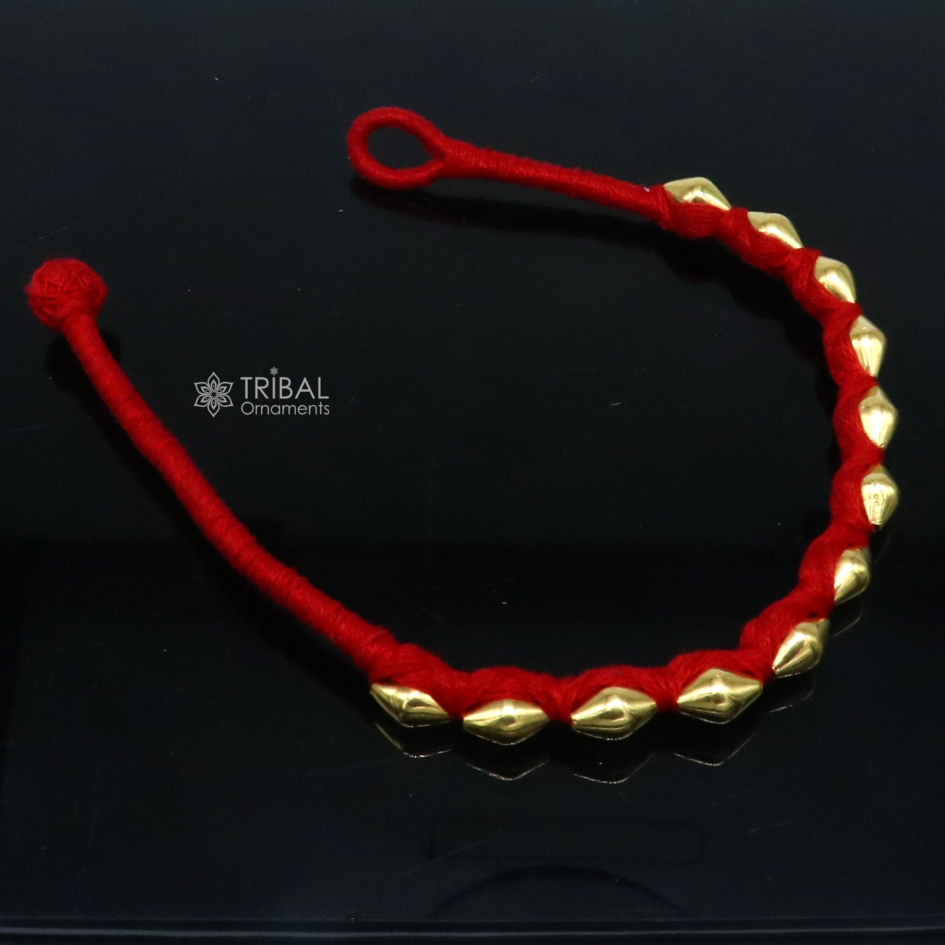 22KT yellow gold handmade dholki beads oval shape bracelet or anklet by TRIBAL ORNAMENTS, featuring custom threads and ethnic tribal design.