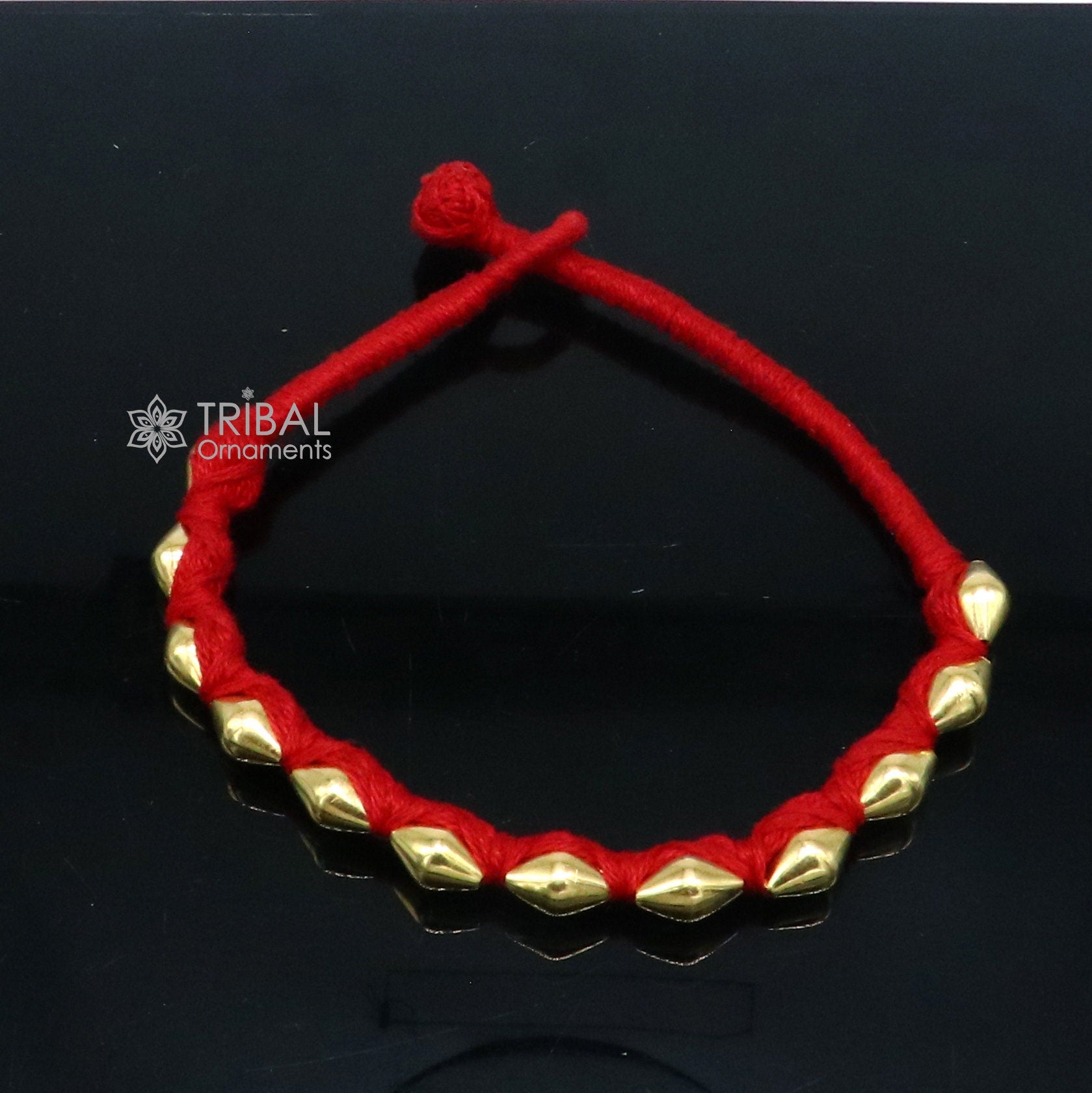 22KT yellow gold handmade dholki beads oval-shaped bracelet or anklet by TRIBAL ORNAMENTS, with custom thread ethnic tribal jewelry.