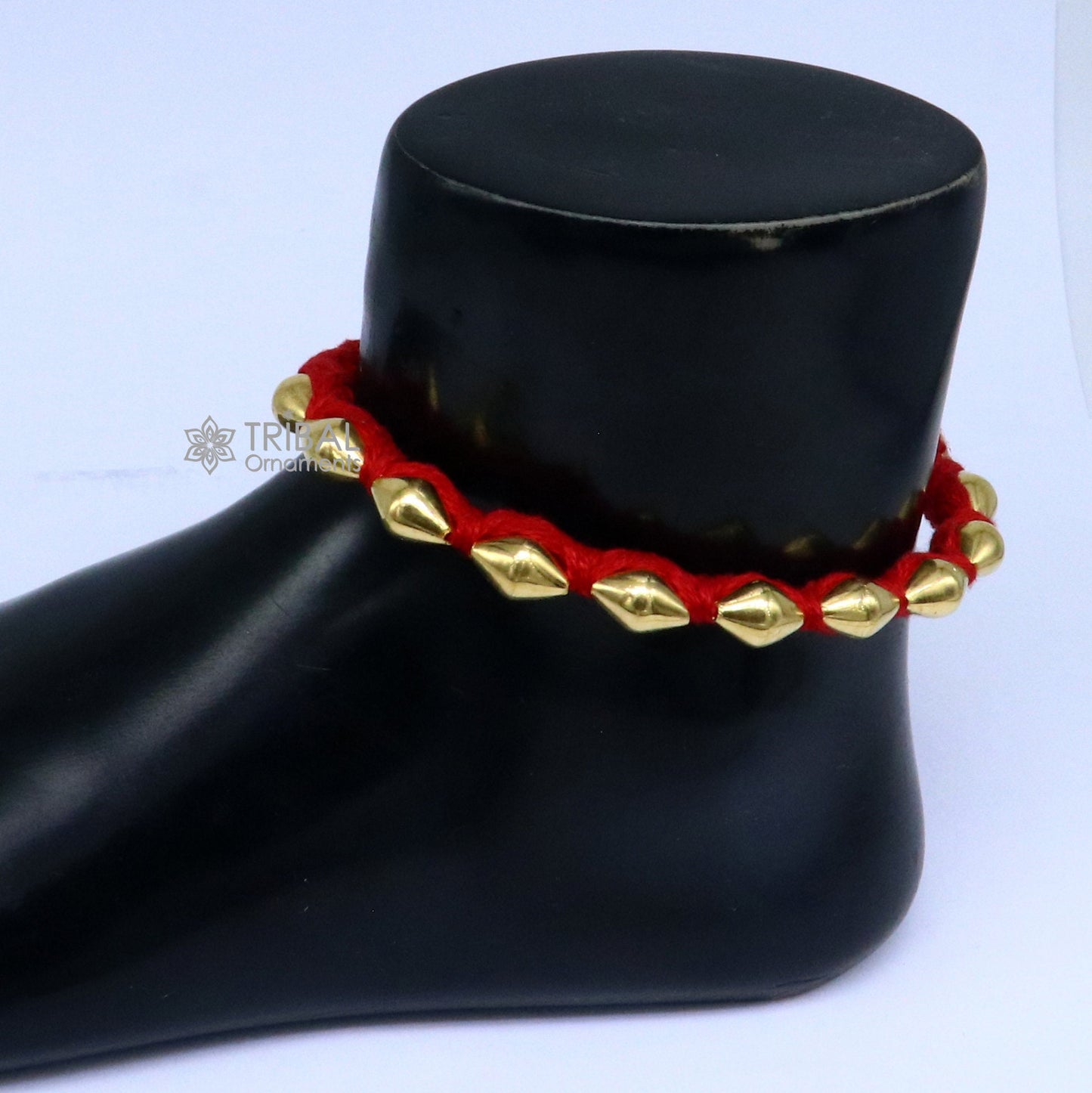 22KT yellow gold handmade dholki beads oval-shaped bracelet or anklet by TRIBAL ORNAMENTS featuring custom thread and ethnic tribal design.