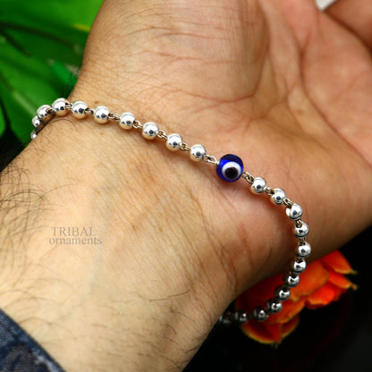 Sterling silver handmade beaded evil eye bracelet by TRIBAL ORNAMENTS, stylish unisex jewelry with intricate bead design.