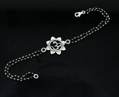 Sterling silver OM design black beaded bracelet with customizable fit, crafted by TRIBAL ORNAMENTS for rakhi gifting.