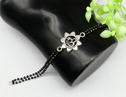 Sterling silver OM design black beaded bracelet from TRIBAL ORNAMENTS, customizable 6 to 8.5 inches, ideal as rakhi or gift.