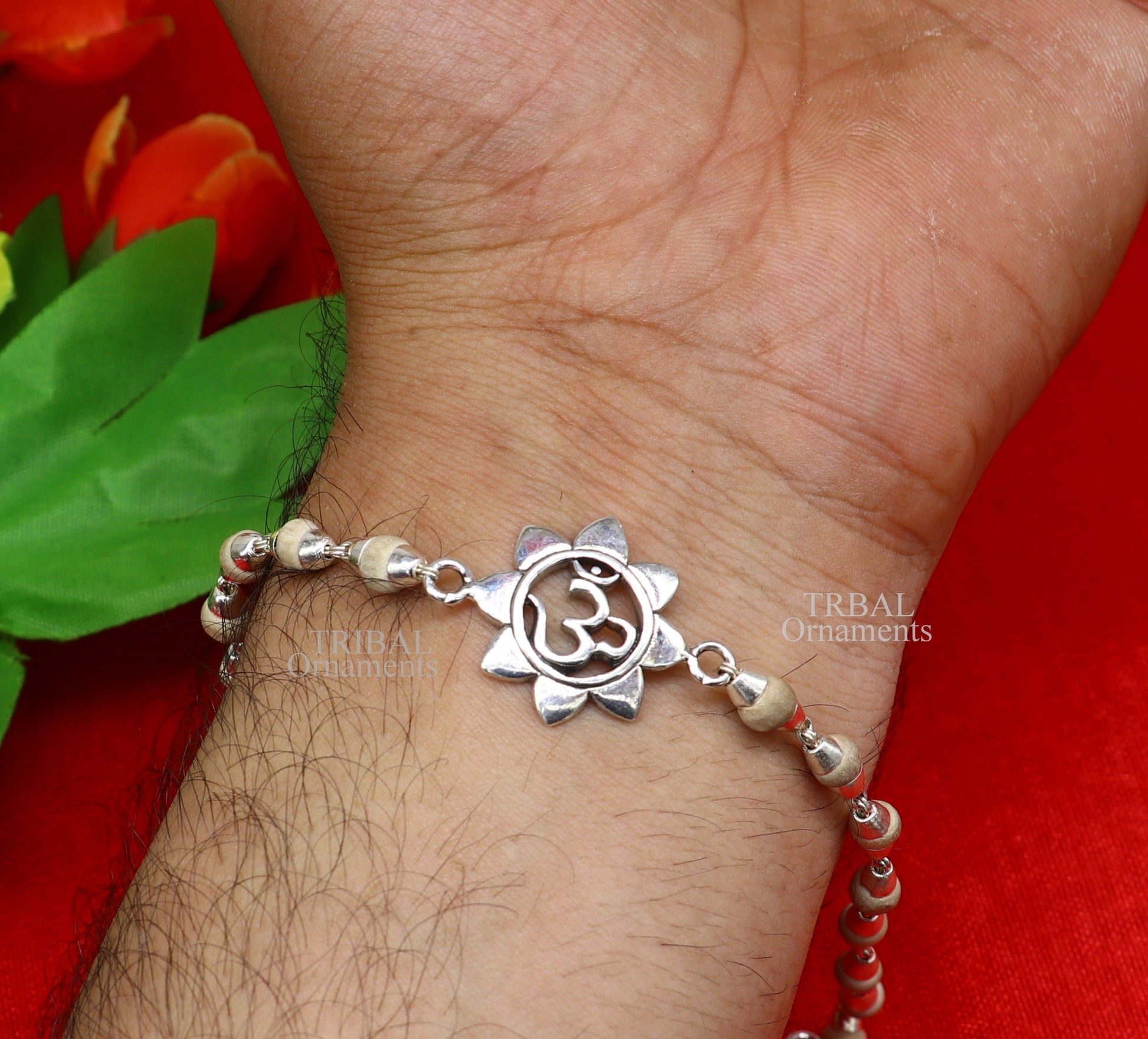 Sterling silver flower OM design Rudraksha beaded bracelet with handmade craftsmanship, featuring Tulsi and Rudraksha beads.