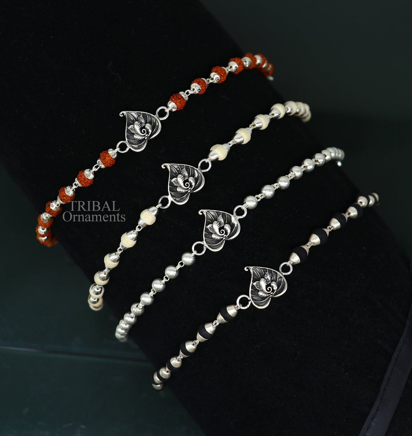 Handmade sterling silver Lord Ganesha on Paan design Rudraksha and Tulsi bead bracelet rakhi with intricate tribal ornament details.
