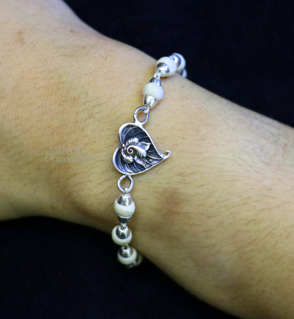 Sterling silver Lord Ganesha on Paan design Rudraksha and Tulsi bead bracelet rakhi with intricate handmade craftsmanship.