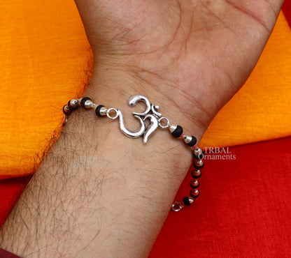Sterling silver OM design Rudraksha beaded bracelet with handmade mantra detailing from Tribal Ornaments.
