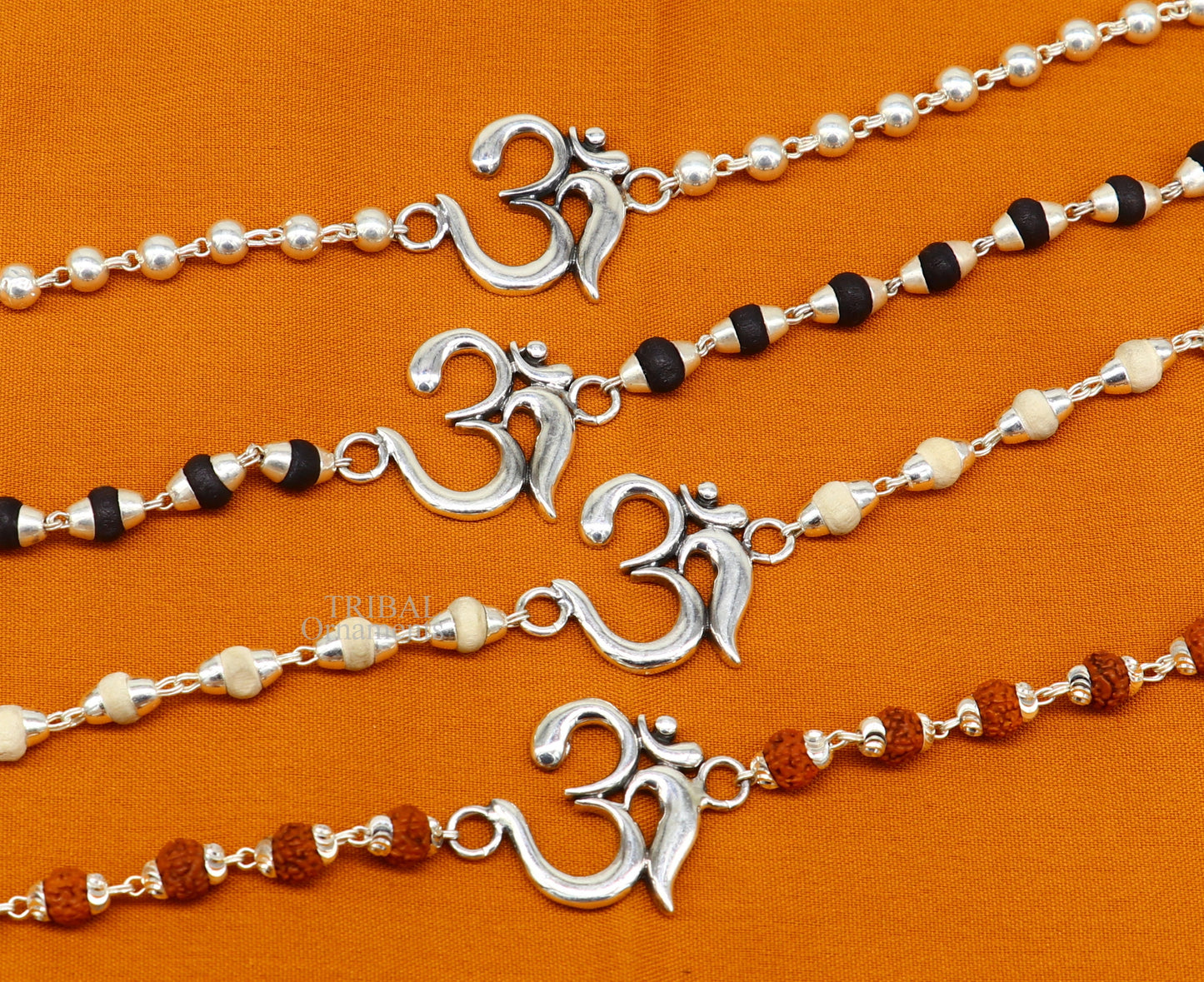 Sterling silver OM design Rudraksha and Tulsi beaded bracelet rakhi with handmade mantra accents, crafted by Tribal Ornaments.