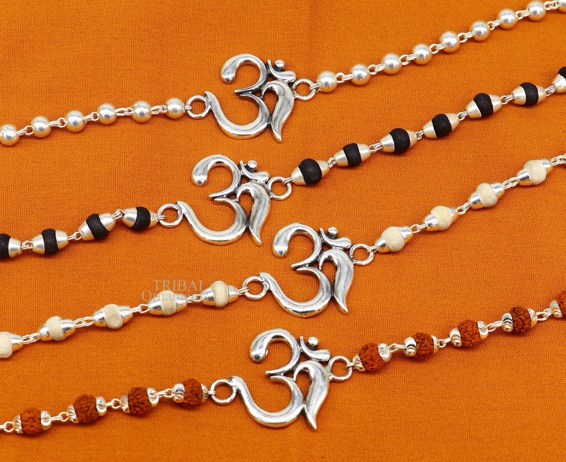 Sterling silver OM design Rudraksha and Tulsi beaded bracelet rakhi with handmade mantra accents, crafted by Tribal Ornaments.