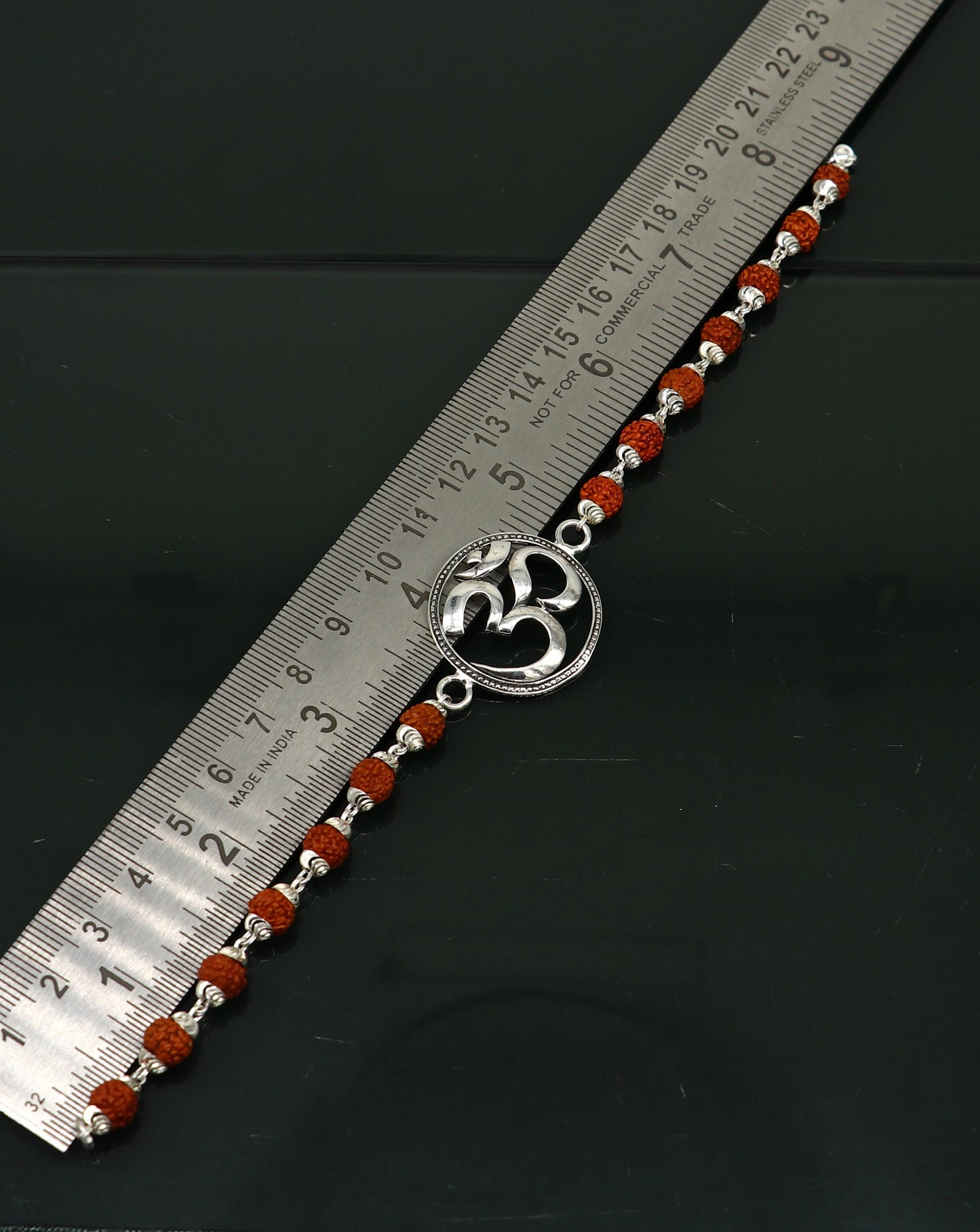 Sterling silver OM Rudraksha bead bracelet with customizable design, featuring Aum symbols, by TRIBAL ORNAMENTS.