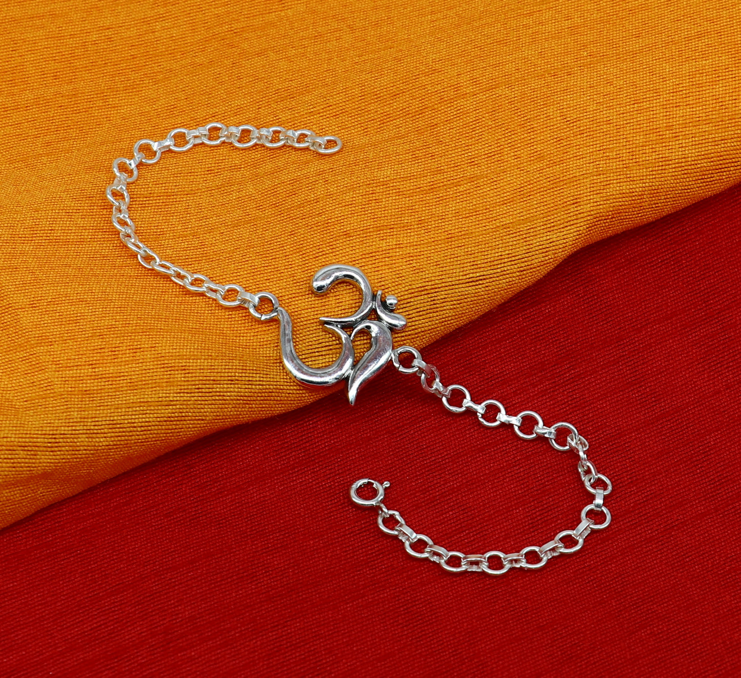 Sterling silver OM mantra bracelet by TRIBAL ORNAMENTS, handmade 7-inch design with intricate Aum Om symbols and adjustable sizes.