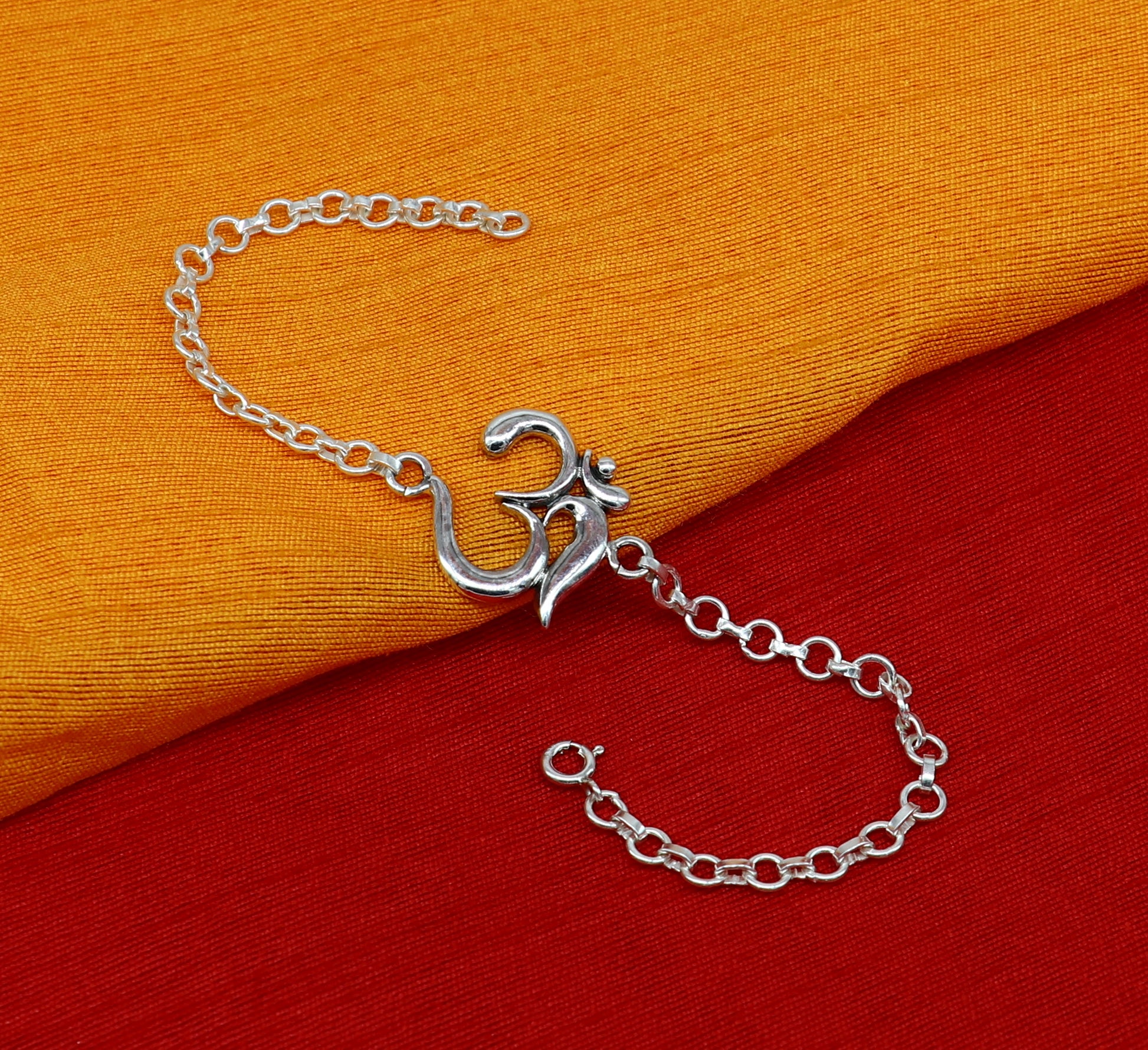 Sterling silver OM mantra bracelet by TRIBAL ORNAMENTS, handmade 7-inch design with intricate Aum Om symbols and adjustable sizes.
