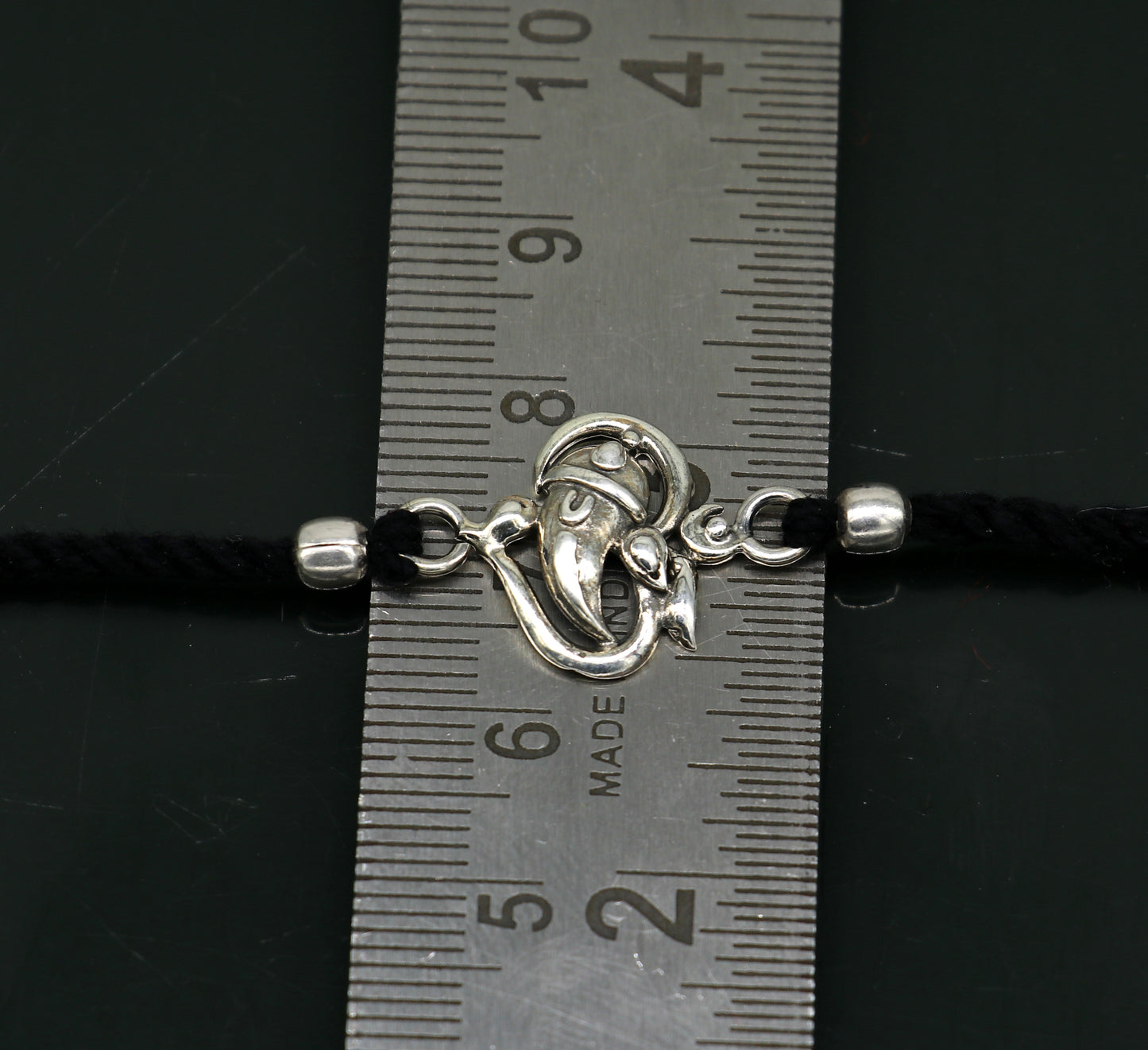 925 sterling silver Om and Ganesha design bracelet by TRIBAL ORNAMENTS, featuring intricate thread Rakhi style craftsmanship.