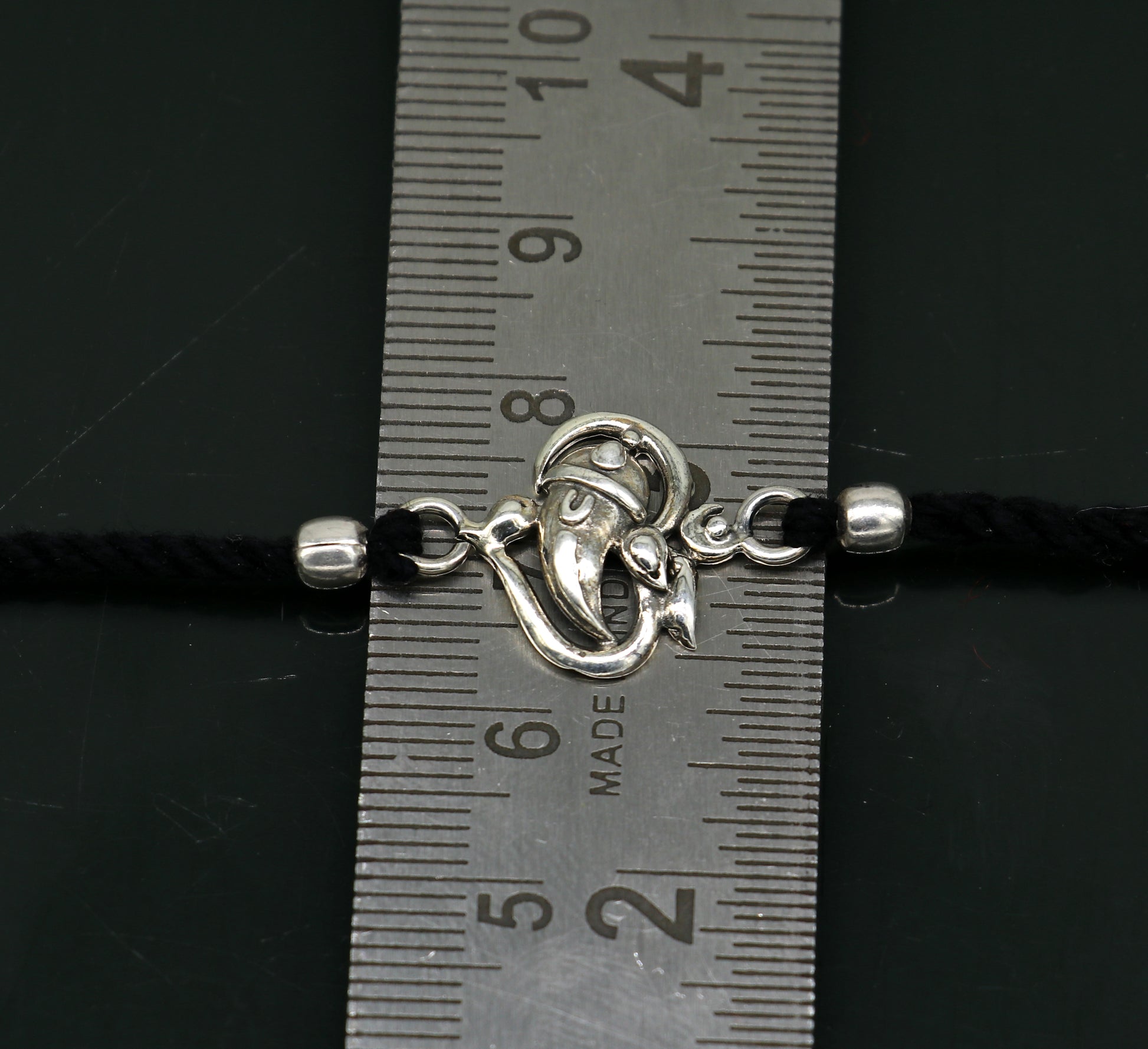 925 sterling silver Om and Ganesha design bracelet by TRIBAL ORNAMENTS, featuring intricate thread Rakhi style craftsmanship.