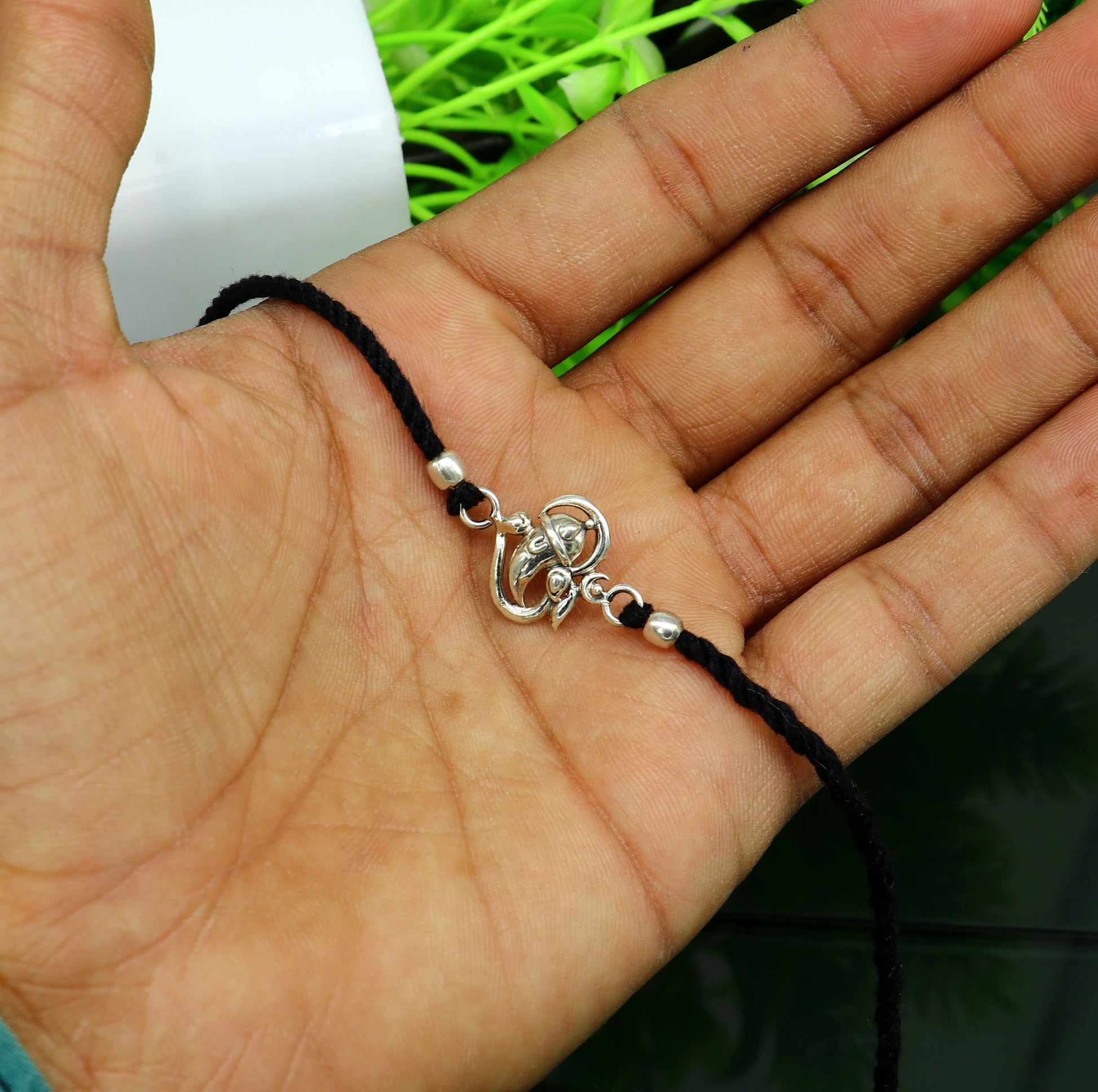 Sterling silver Om with Ganesha design bracelet from TRIBAL ORNAMENTS, featuring intricate spiritual motifs on thread bracelet.