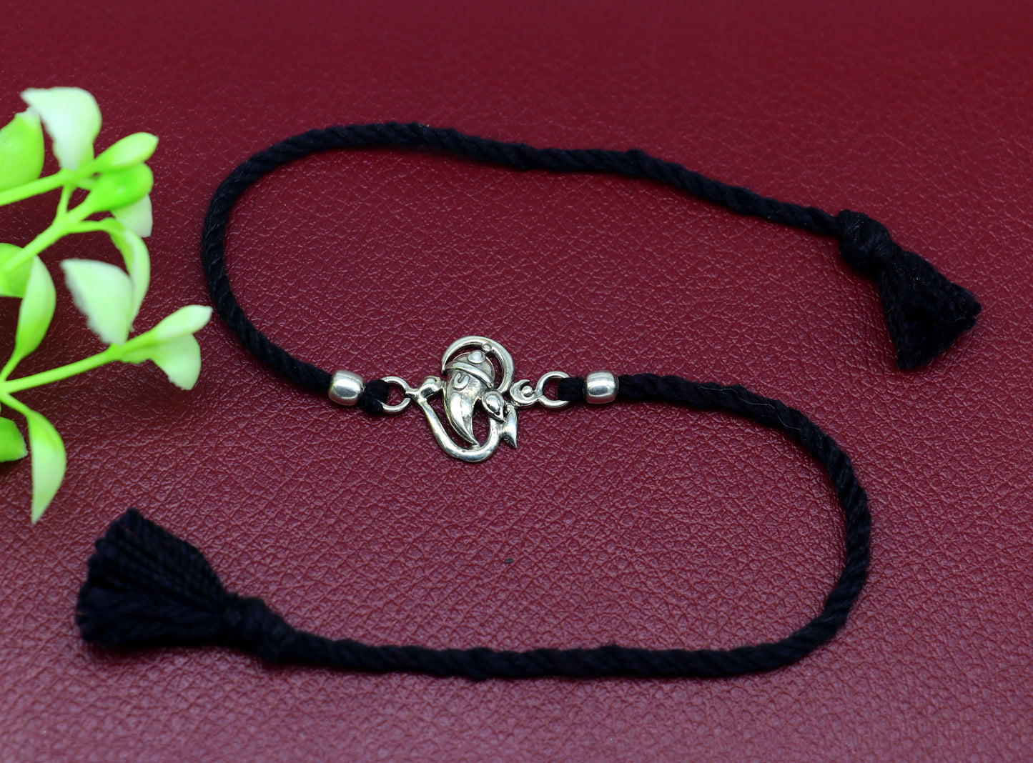 925 sterling silver Om with Ganesha design bracelet by TRIBAL ORNAMENTS featuring intricate threading and spiritual symbols.