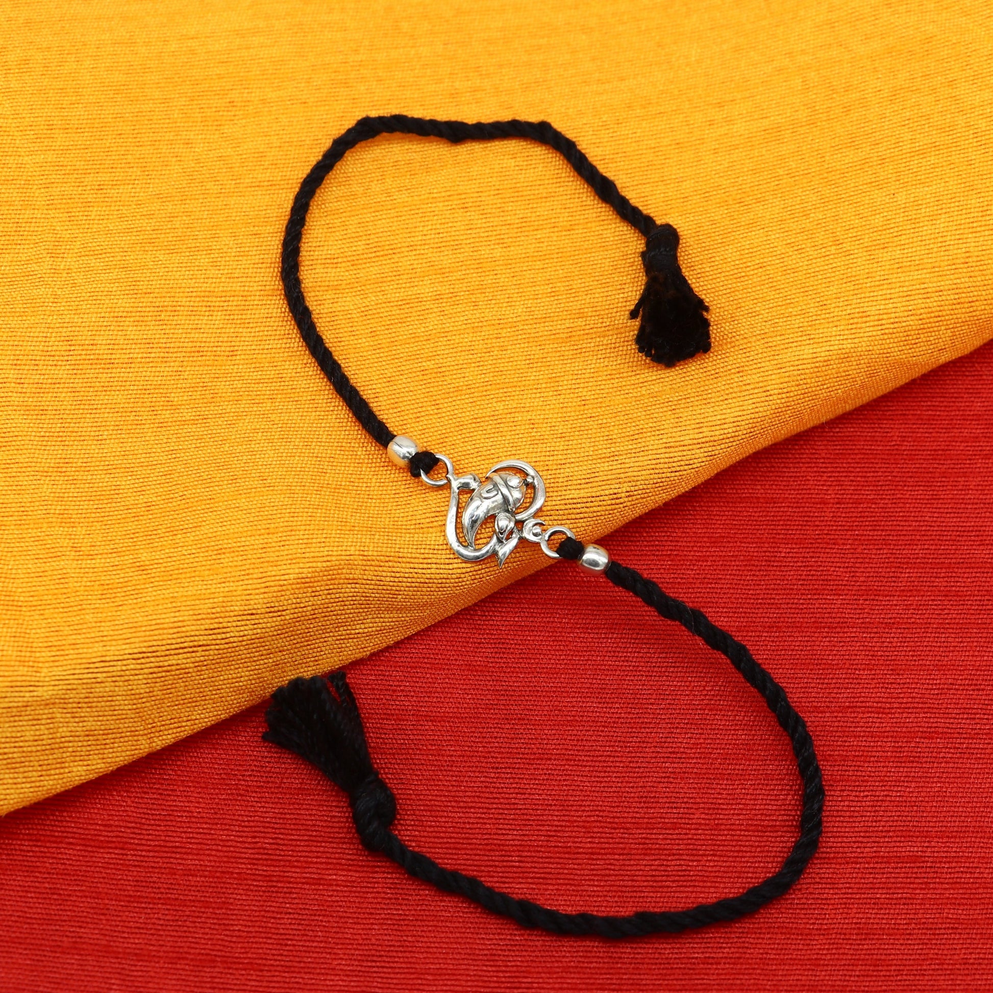 925 sterling silver Om and Ganesha design bracelet from Tribal Ornaments, featuring intricate thread Rakhi style craftsmanship.