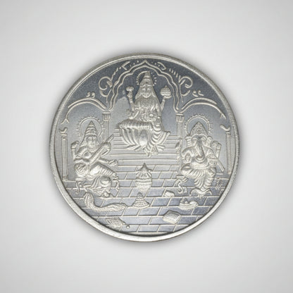 Silver coin featuring Ganesha, Lakshmi, and Saraswati images, 100 grams, with tribal ornament design for Diwali celebrations.
