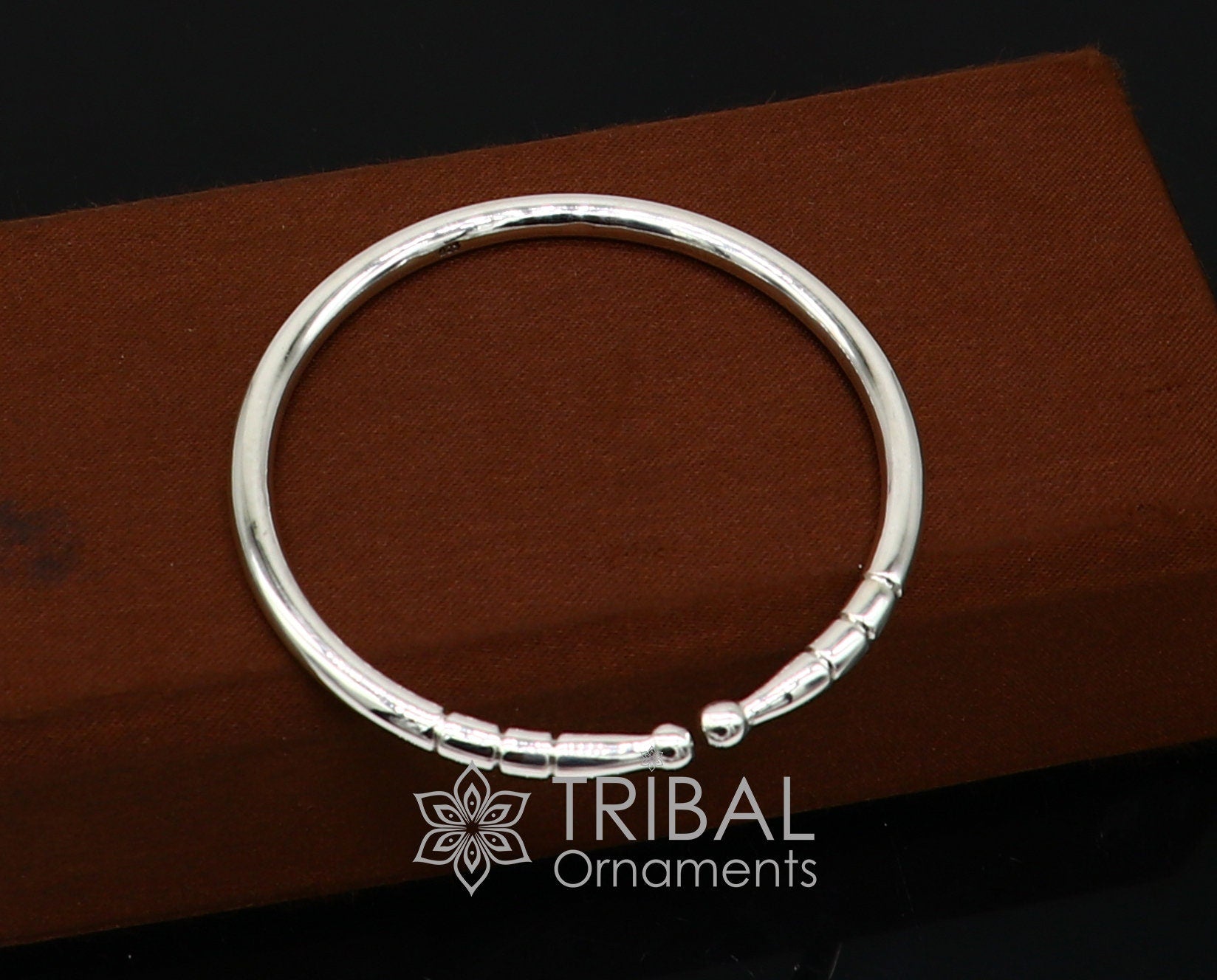 Sterling silver handmade bangle bracelet with a shiny, plain design, adjustable and trendy for unisex wear by Tribal Ornaments.