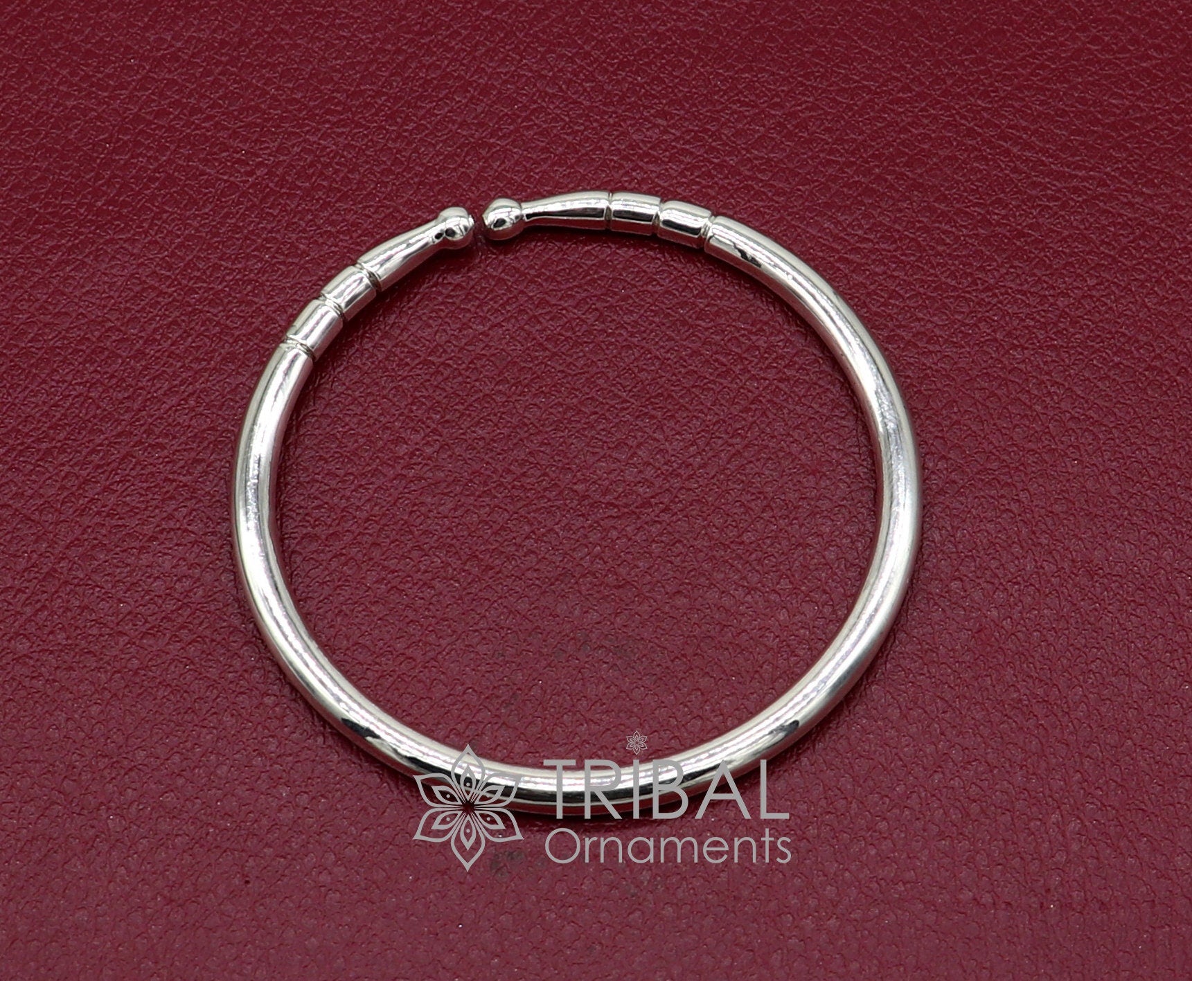 Sterling silver handmade bangle bracelet with a shiny, plain design, adjustable for unisex wear, by TRIBAL ORNAMENTS.