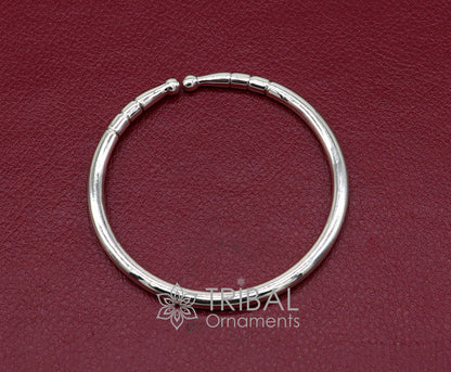 Sterling silver handmade bangle bracelet with a shiny, plain design, adjustable for unisex wear, by TRIBAL ORNAMENTS.