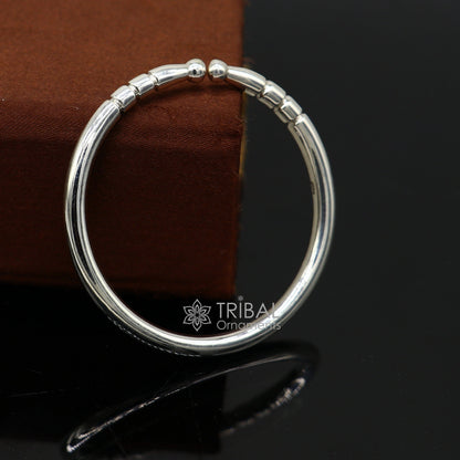 Sterling silver kids bangle bracelet with a smooth, shiny finish, adjustable unisex design by Tribal Ornaments.