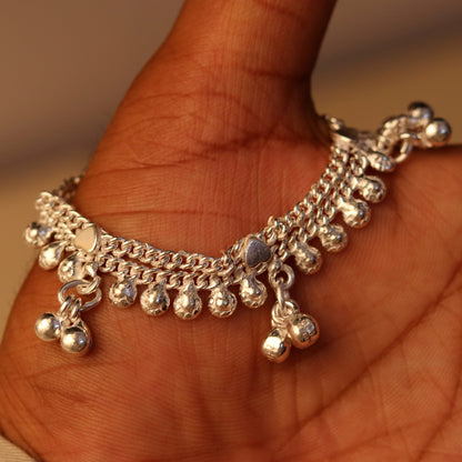 Handmade sterling silver baby anklet with hanging noisy bells, unisex design, featuring a small baby foot charm for infants.