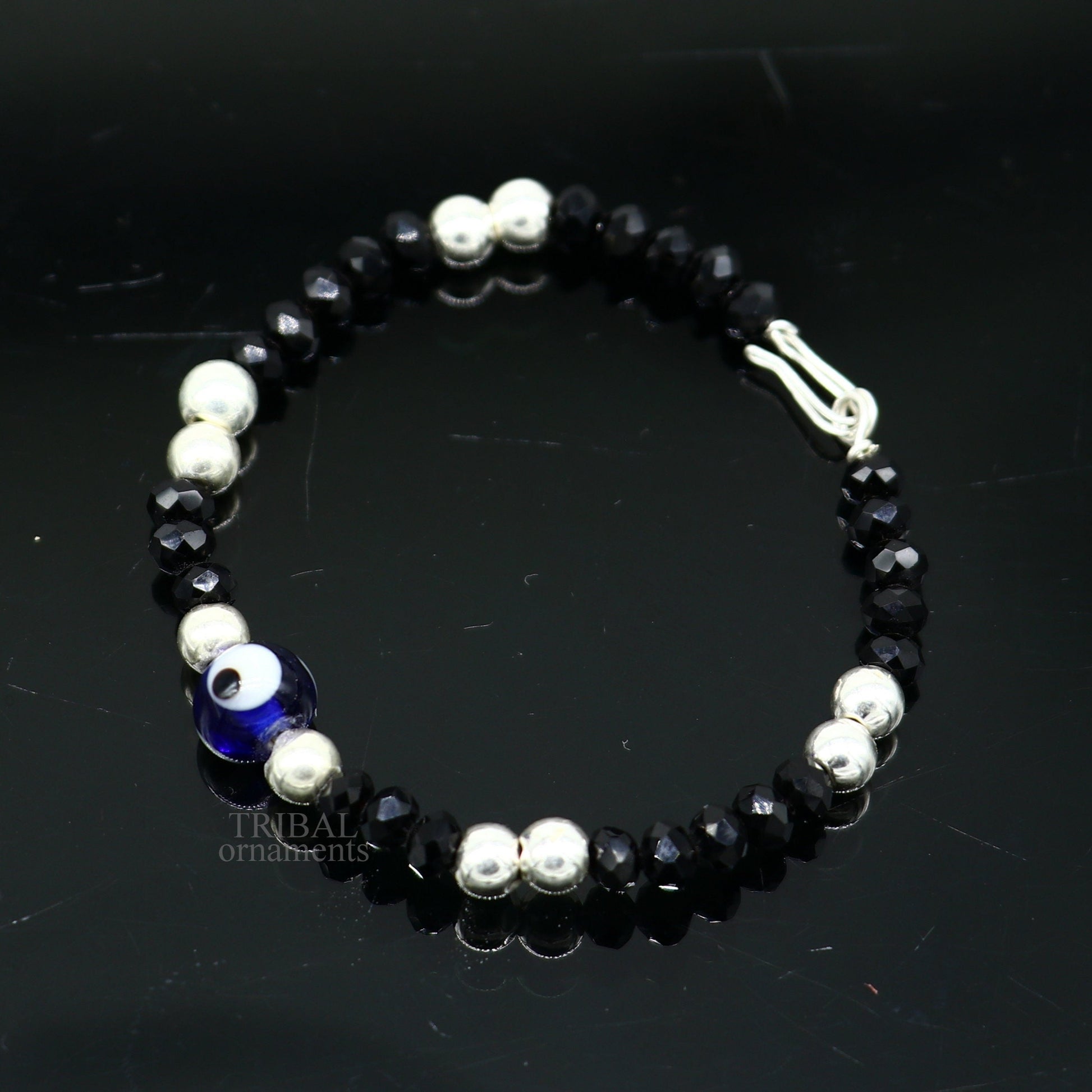 Sterling silver handmade beaded evil eye bracelet by Tribal Ornaments, stylish unisex kids jewelry with blue eye charm.