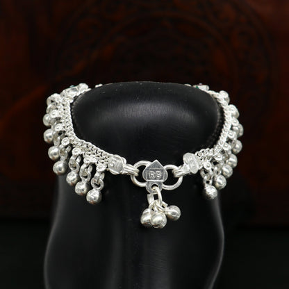 Handmade sterling silver anklet with five waved jingling bells, designed for kids, featuring a baby foot charm and tribal style.