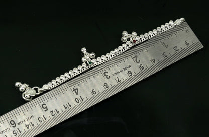 Handmade 5-inch sterling silver baby ankle bracelet with dainty charms, unisex design, crafted by Tribal Ornaments.
