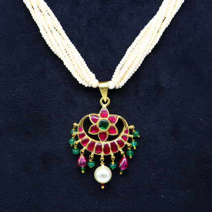Sterling silver Tribal Ornaments jewelry set with green and red kundan pendant, multi-strand pearls, and trendy necklace design.