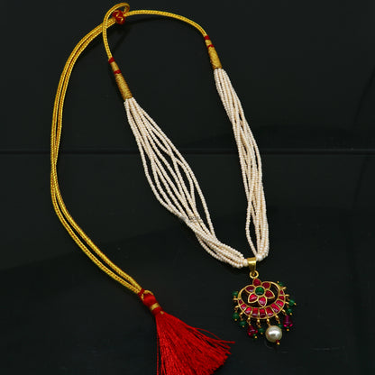 Sterling silver trendy necklace set with green and red kundan work pendant, multiline pearl strings, and matching jewelry set.