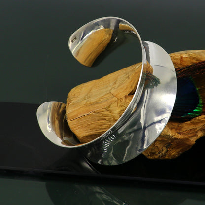 Sterling silver cuff bracelet with a unique curved design, shiny and elegant, by TRIBAL ORNAMENTS.