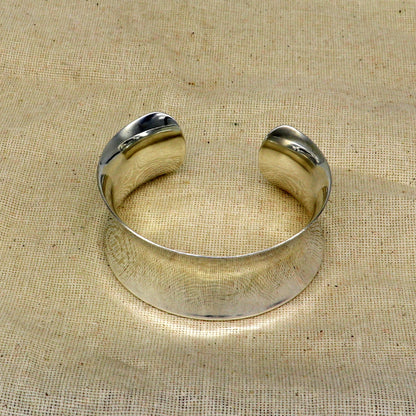 Sterling silver cuff bracelet with a unique curved design, bright shiny finish, trendy elegant style, by TRIBAL ORNAMENTS.