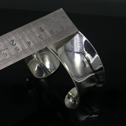 Sterling silver cuff bracelet with a unique curved design and bright shiny finish, stylish and elegant jewelry by Tribal Ornaments.