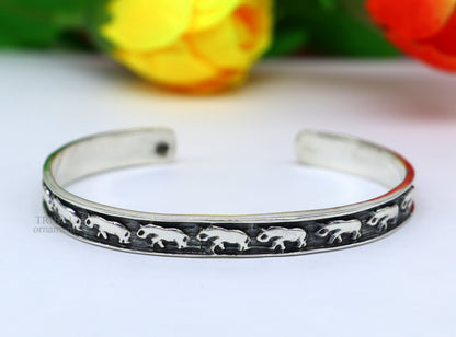 Sterling silver elephant design bangle cuff bracelet by TRIBAL ORNAMENTS, featuring a waved open-face elephant pattern for unisex jewelry.