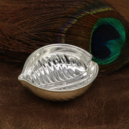 Sterling silver handcrafted tilak and sindur bowls with intricate design, used as puja utensils for home temple rituals.