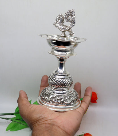 Handcrafted 925 sterling silver vintage oil lamp or candle stand with intricate detailing, used as puja utensil or decorative silver figure.