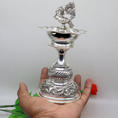 Handcrafted 925 sterling silver vintage oil lamp or candle stand with detailed designs, used as puja utensils or decorative silver figurine.