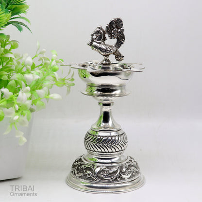 Handcrafted 925 sterling silver vintage oil lamp or candle stand, traditional Deepak for puja, with detailed silver figurine and utensils.