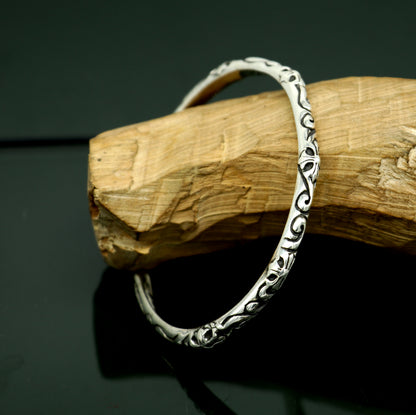 Sterling silver tribal style bangle cuff bracelet for men and women, handcrafted with a glossy, graceful design.