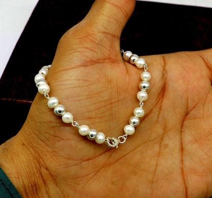 Sterling silver round bead and pearl bracelet by TRIBAL ORNAMENTS, featuring handmade 5.5mm silver beads and elegant pearls.