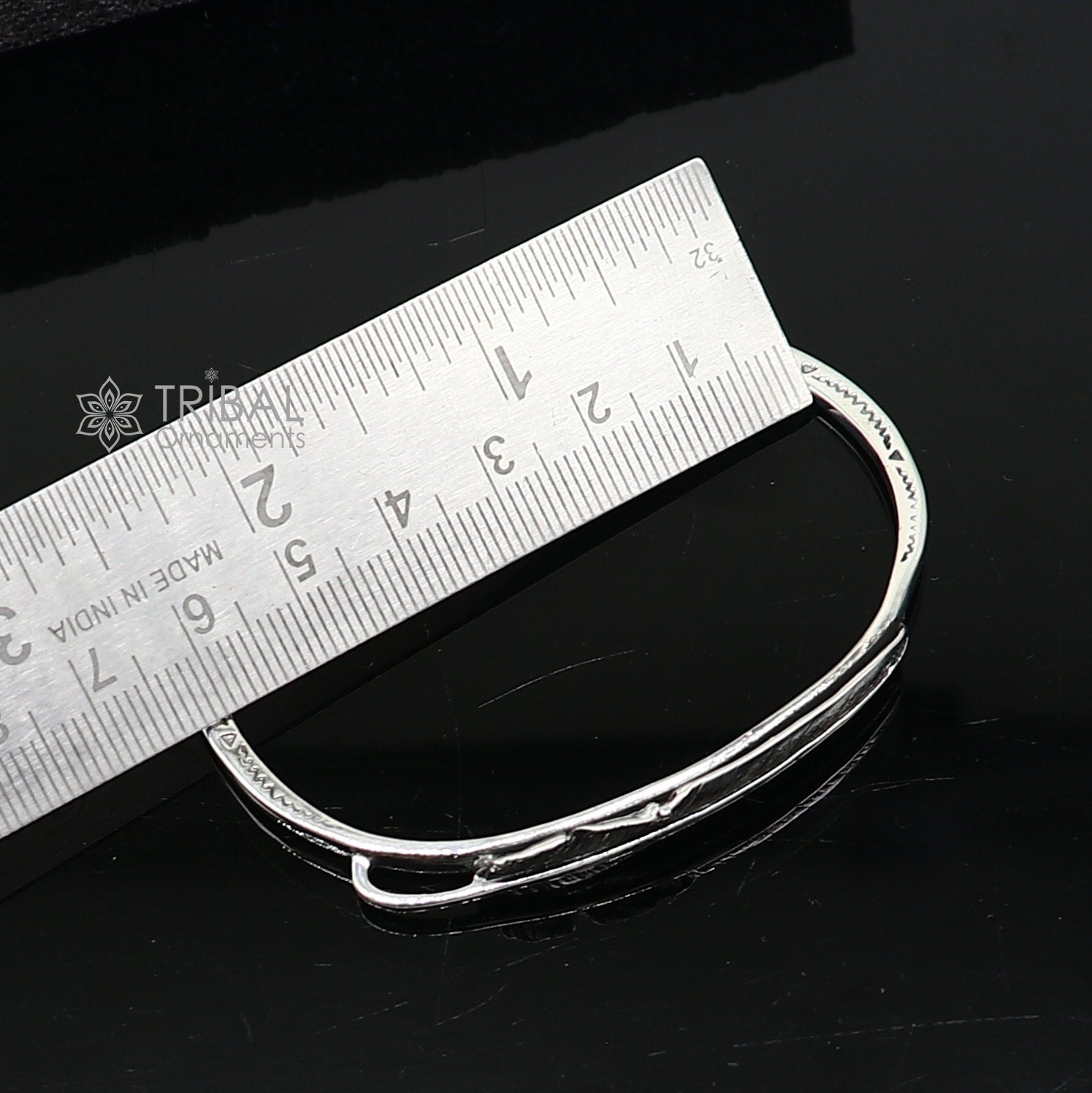 Sterling silver feather design adjustable cuff bracelet by TRIBAL ORNAMENTS, unisex modern jewelry with intricate feather details.