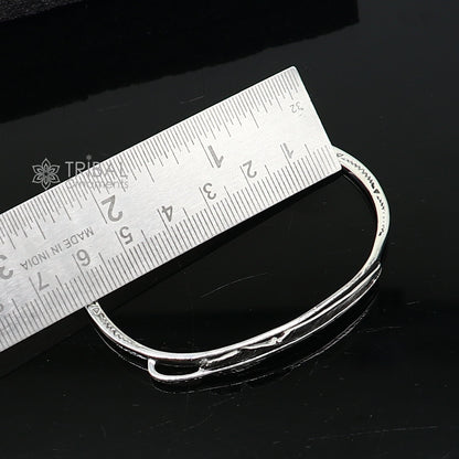 Sterling silver feather design adjustable cuff bracelet by TRIBAL ORNAMENTS, unisex modern jewelry with intricate feather details.