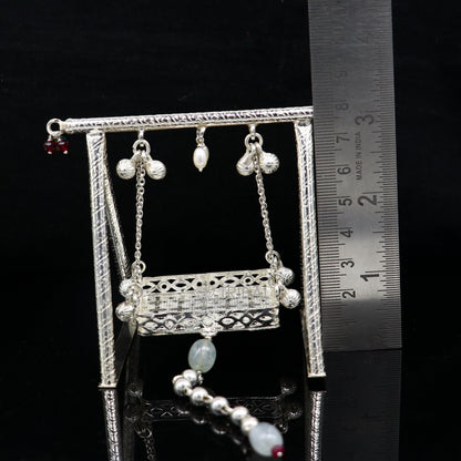 Sterling silver handmade Bal Gopala jhula depicting Little Krishna on a swing, crafted by TRIBAL ORNAMENTS, silver art.