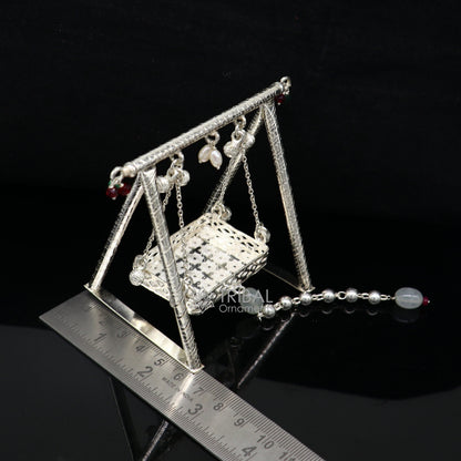 925 silver handmade Bal Gopala swing depicting Little Krishna on a decorative silver jhula, detailed silver art of Laddu Gopal.