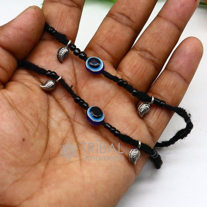 Sterling silver handmade beads with evil eye charms on a customized thread ankle bracelet by TRIBAL ORNAMENTS.